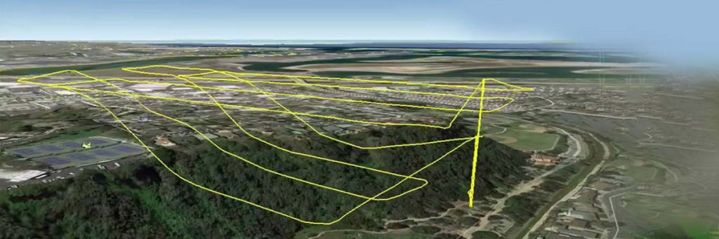 مسیر تعیین شده برای پرواز کوادکوپتر بر فراز یک دشت سر سبز با خطو زرد مشخص شده اند